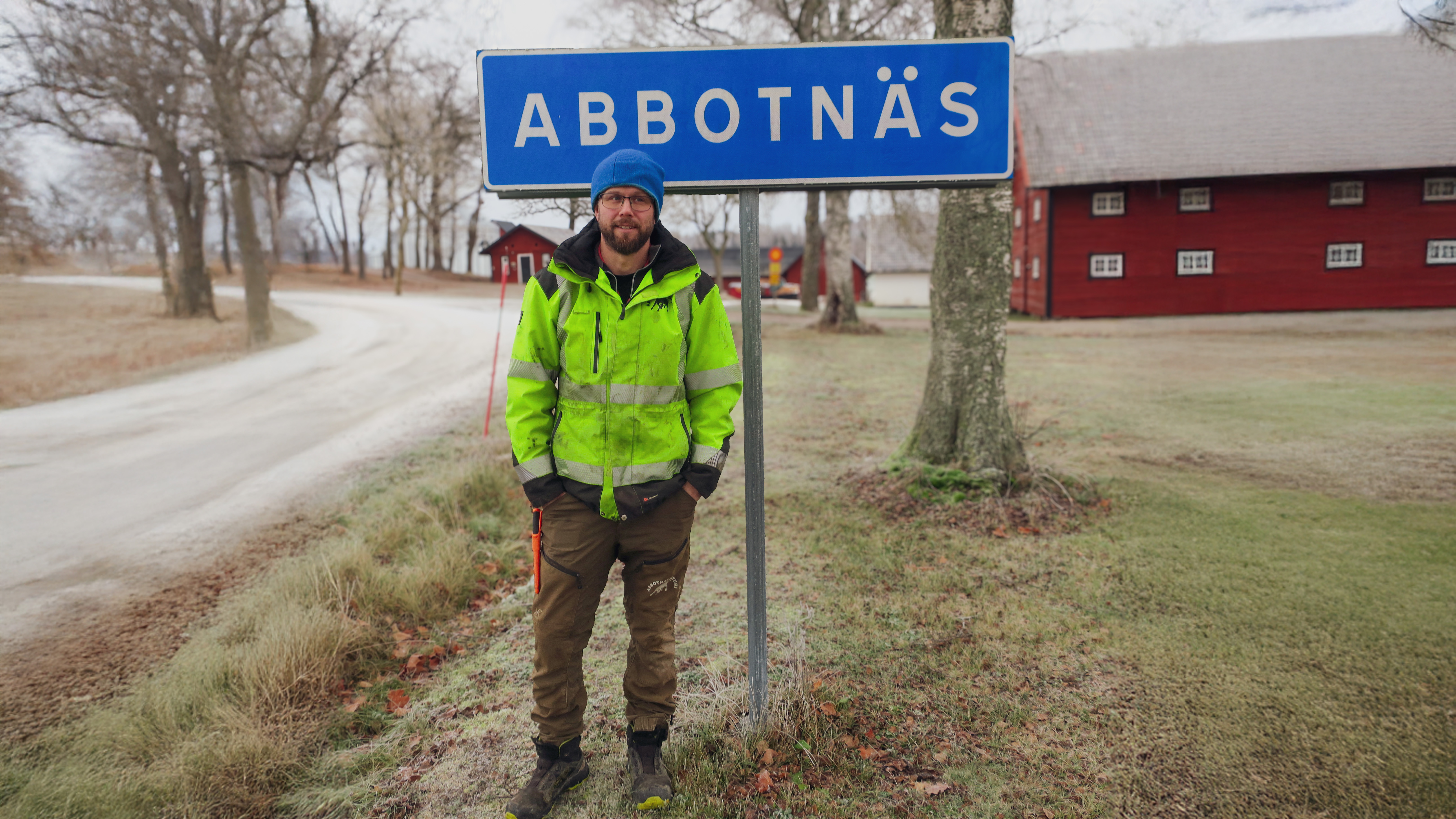 Bild på Mattias Larsson på Abbotnäs säteri framför en vägskylt med texten "Abbotnäs".