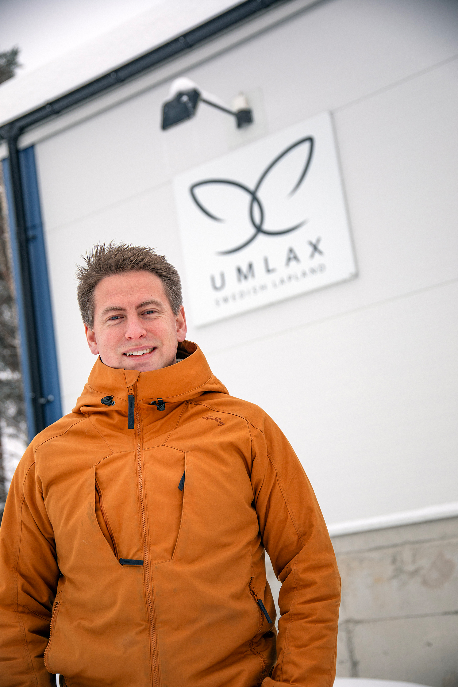 Bild på Emanuel Nygren, vd för Umlax, som står utanför företagsbyggnaden med skylt där det står "Umlax".