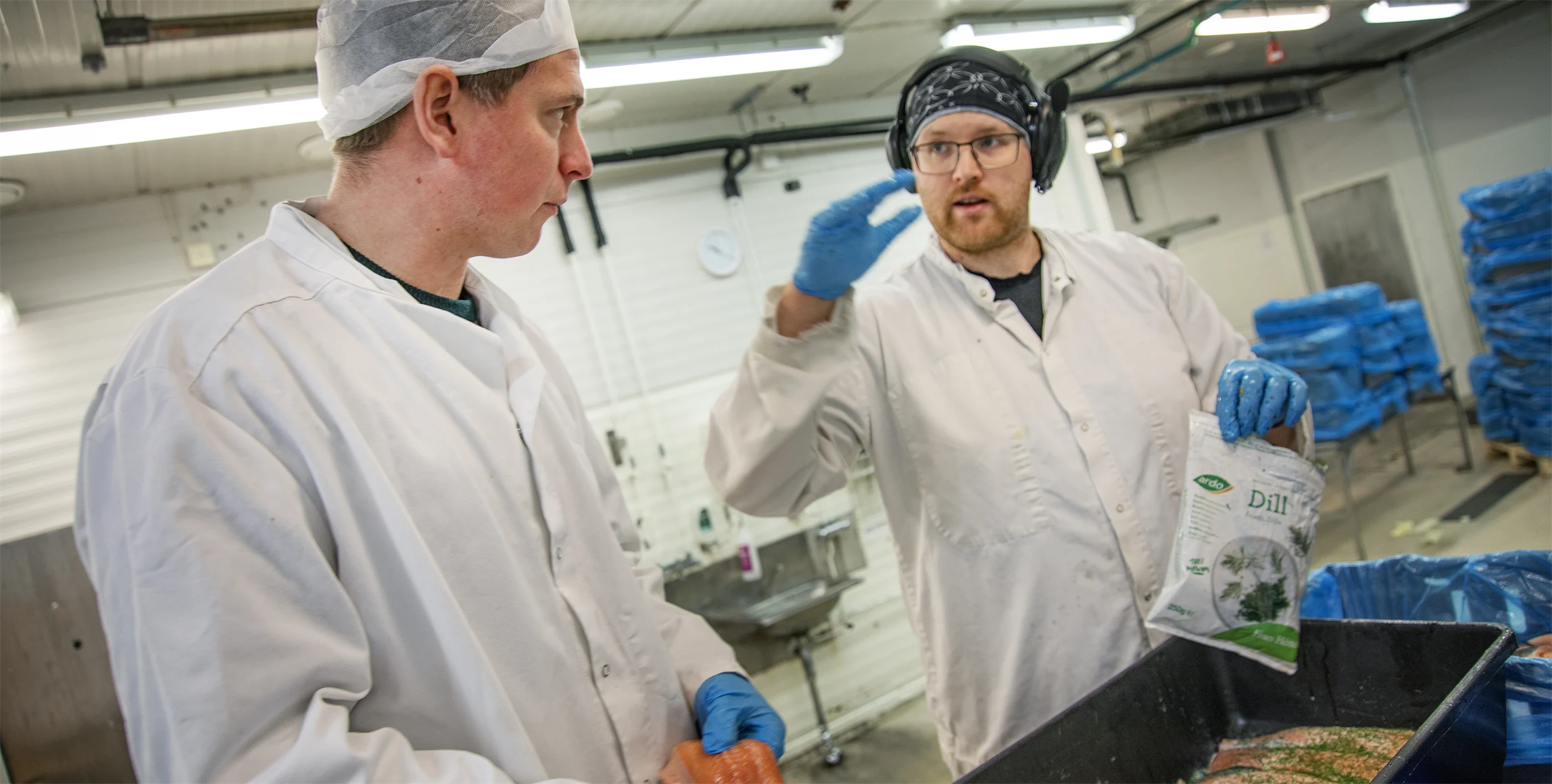 Bild på Emanuel Nygren i samspråk med Per Christoffer ”PC” Ekbäck som är i färd med att grava fjällröding i förädlingsanläggningen i Vilhelmina.